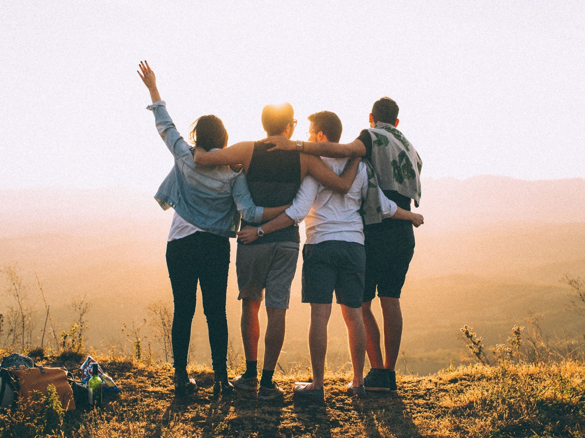 groupe d'amis regardant un paysage au coucher du soleil
