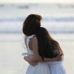 mère et fille enlacées sur une plage au sable fin lors d'un séjour en duo