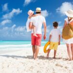 famille marchant sur une plage ensoleillée, face à la mer, ambiance vacances estivales